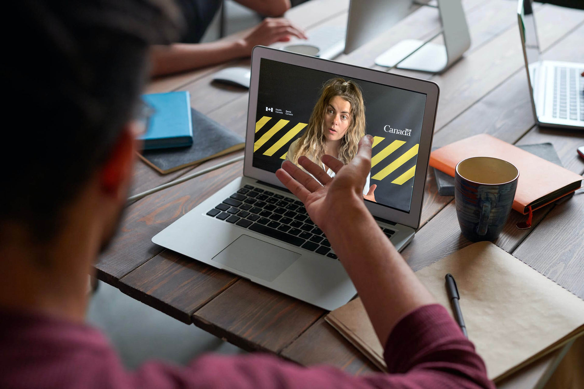 A man at a table looking a presentation on a laptop