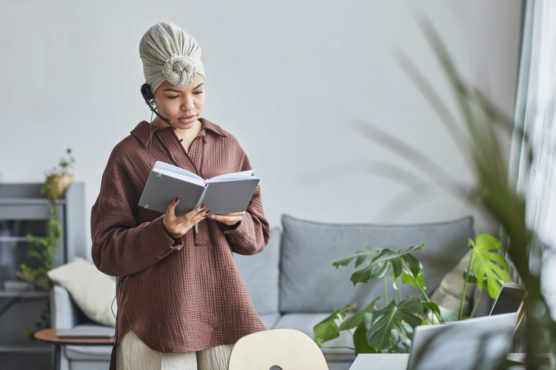 A woman standing, reading a book