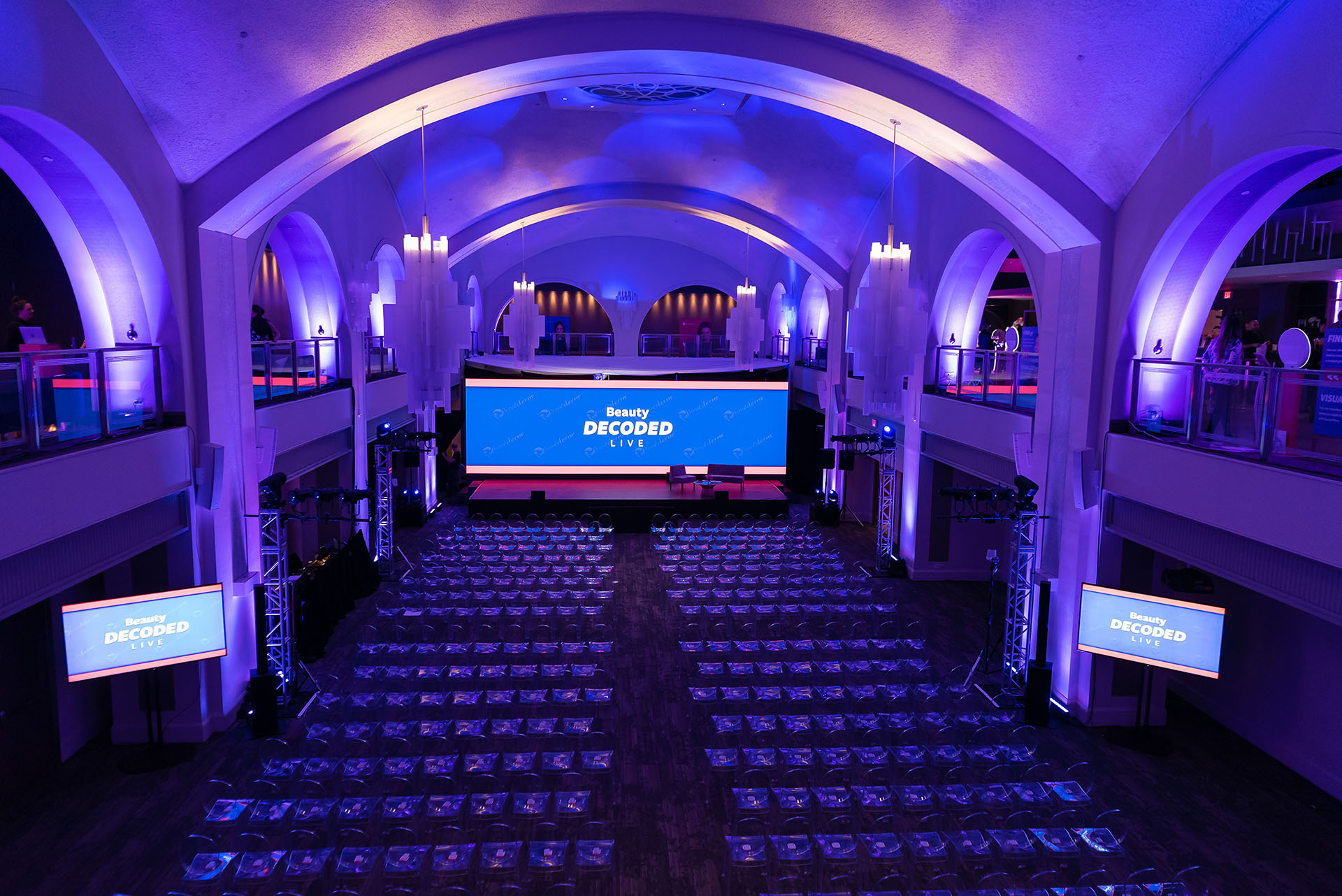 A large room set up with rows of chairs for an event conference