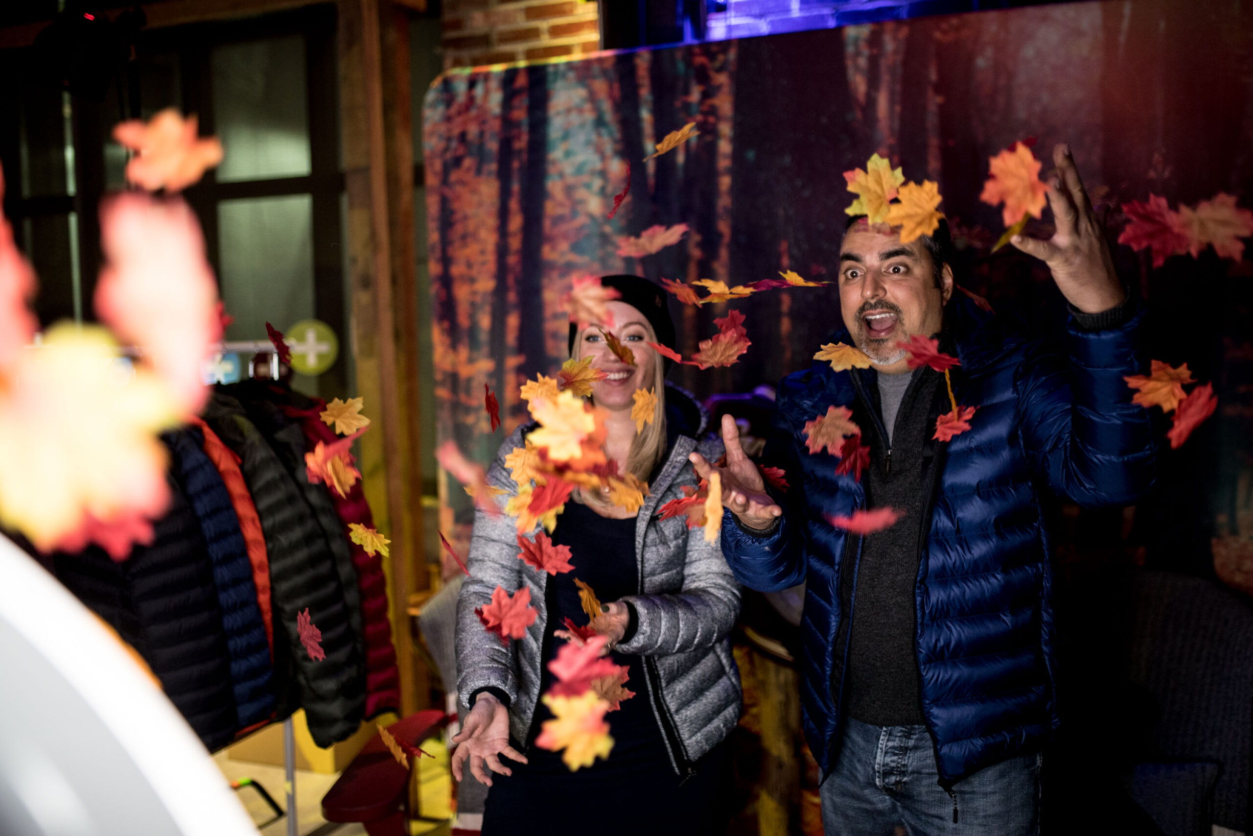 a man and woman tossing fall leaves