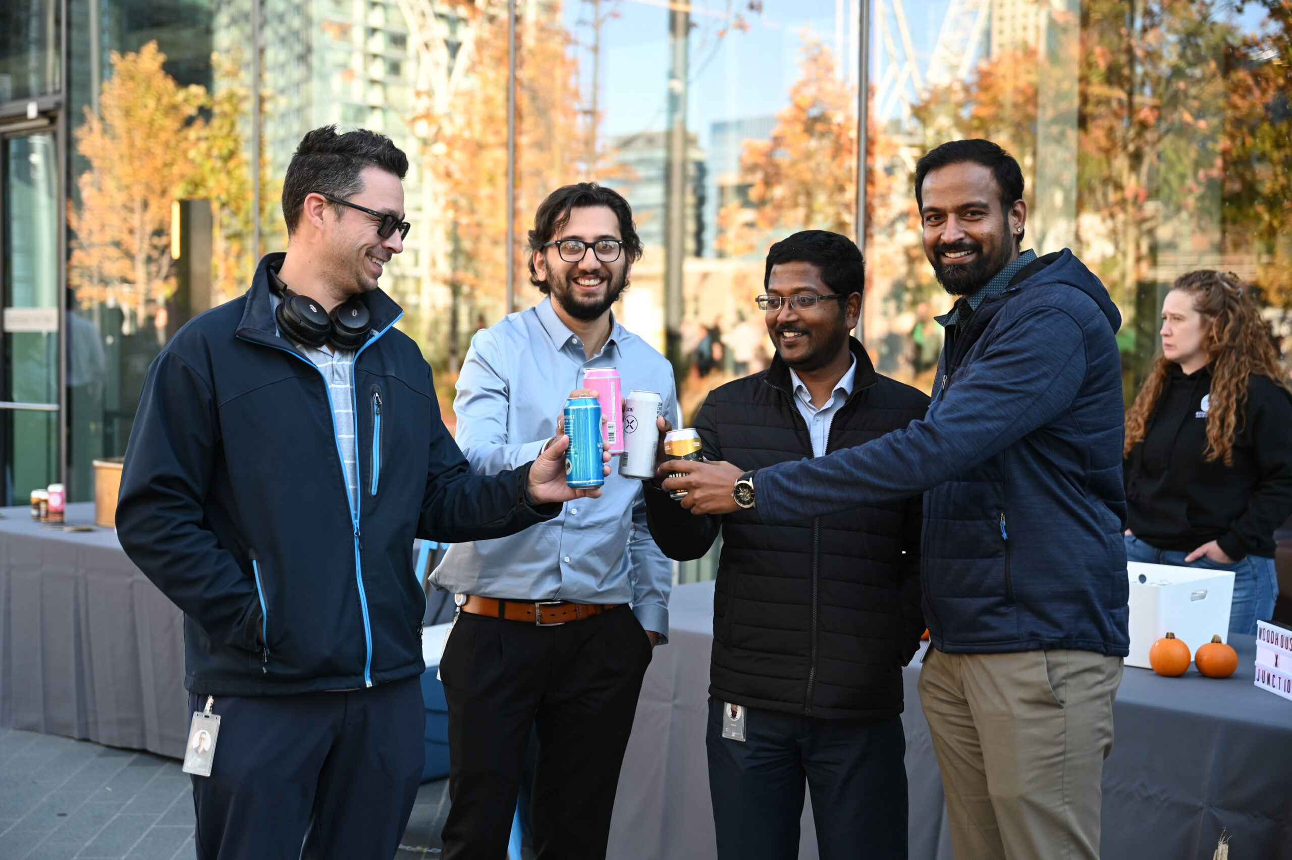 a group of men standing outside holding canned drinks