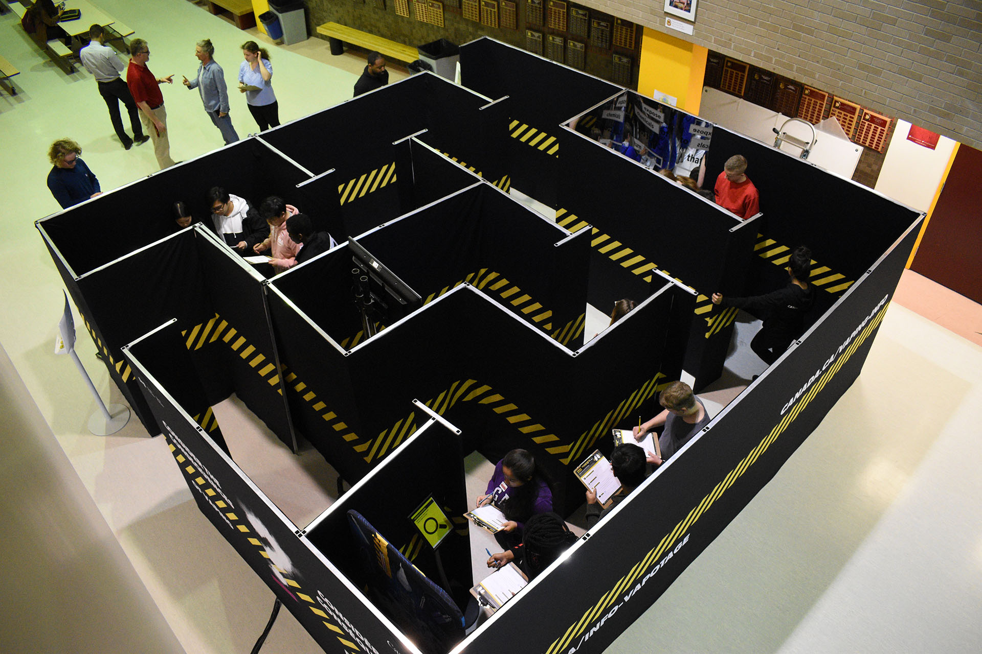 a group of students moving through different activities in a life-sized maze
