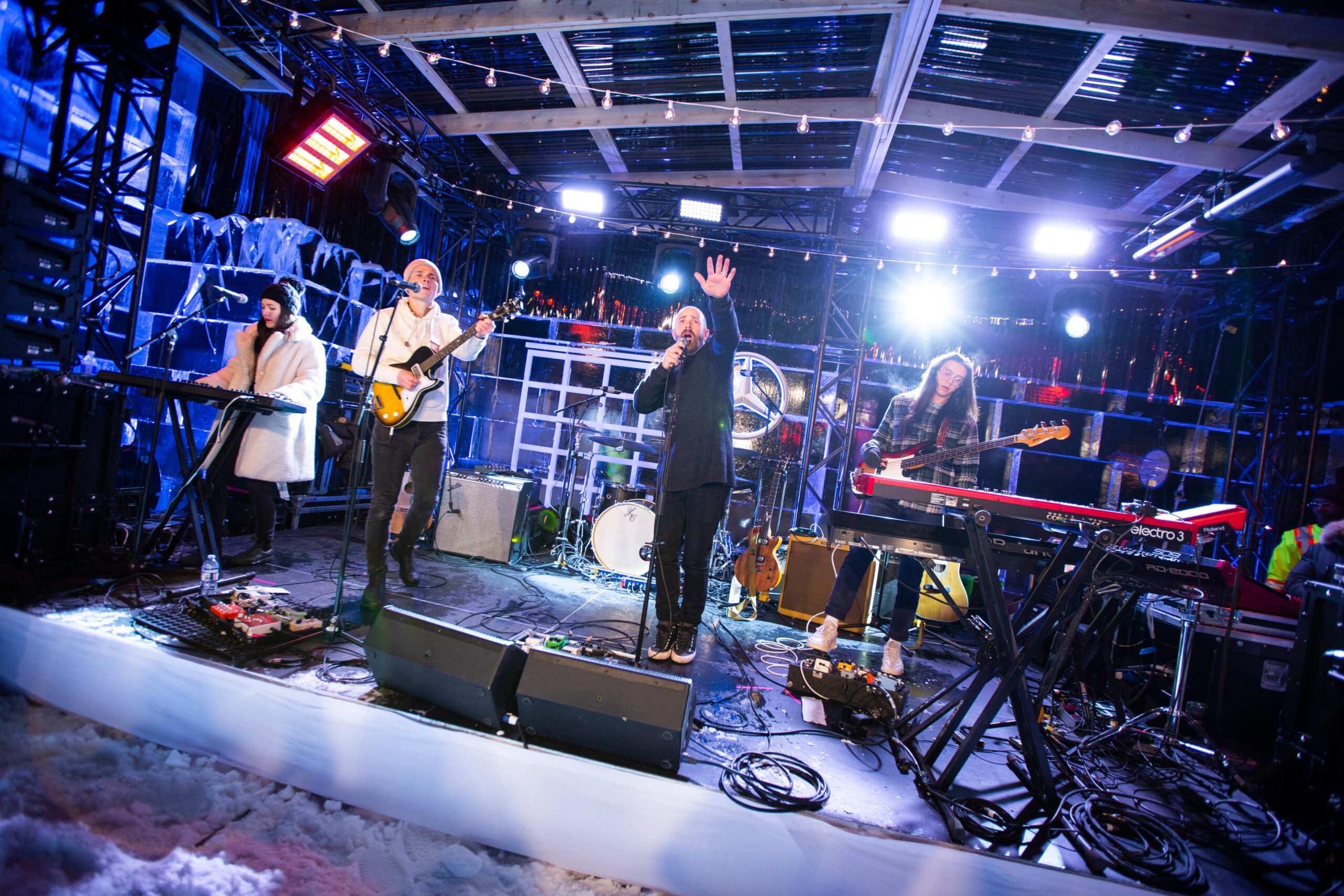a band performing on an outdoor stage surrounded by snow