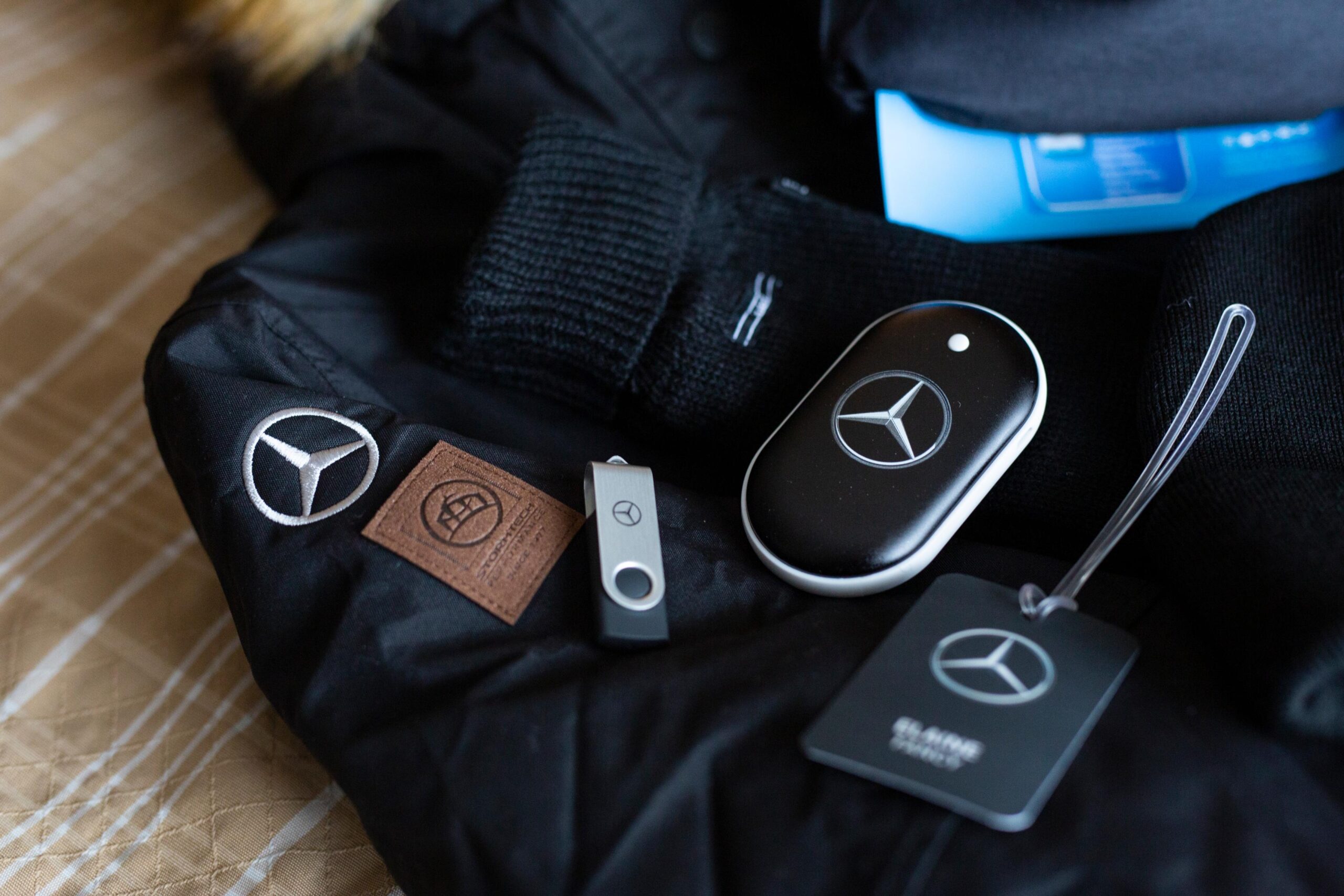 Mercedes Benz luggage tag, USB stick, hat, and a black jacket