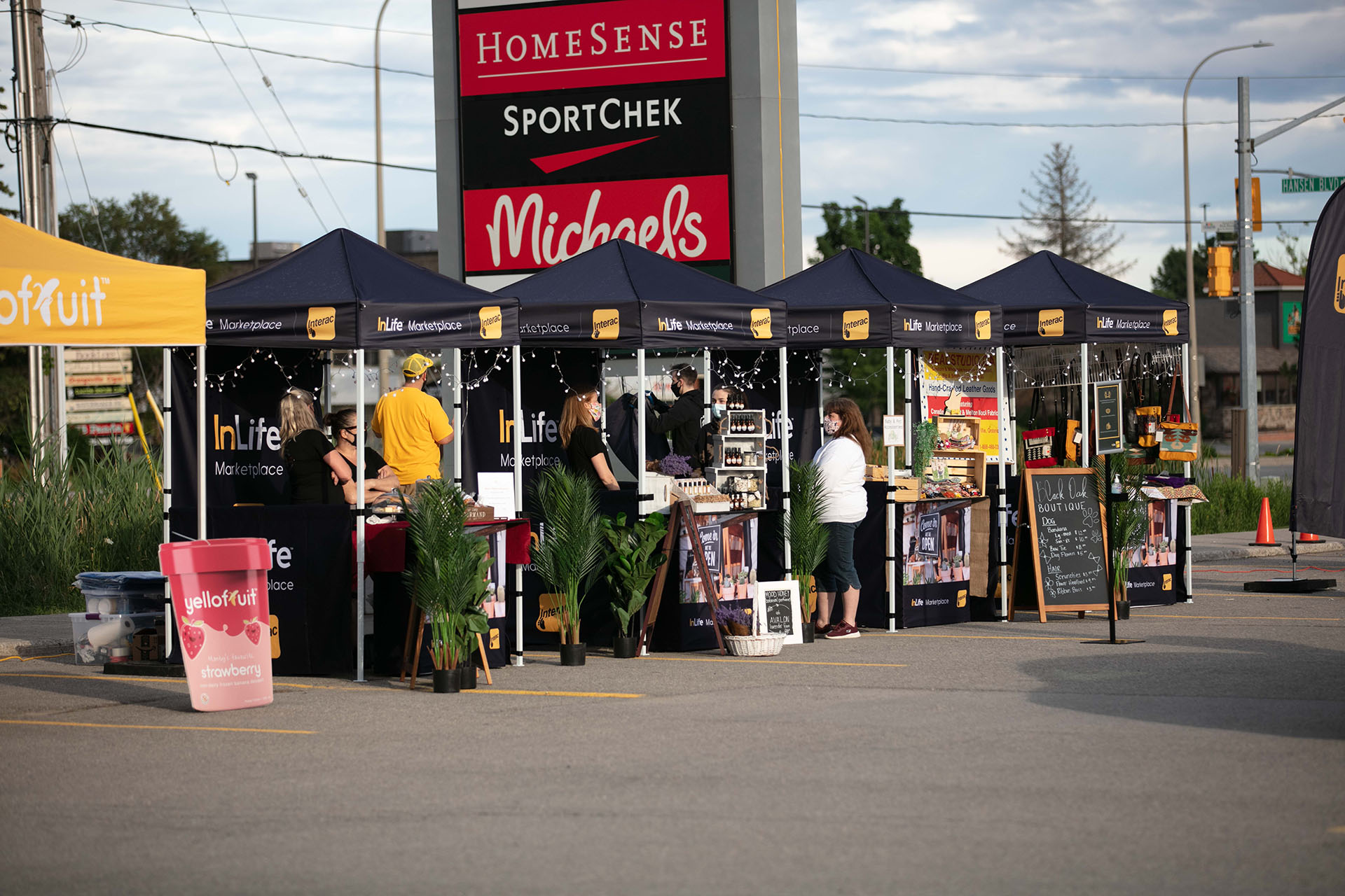 A row of vendors stands in a parking lot