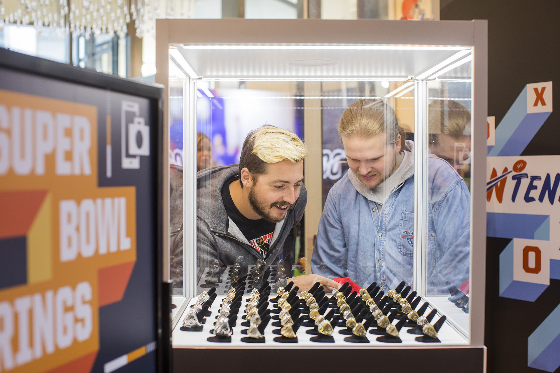 Fans looking at NFL Superbowl rings in a clear display case