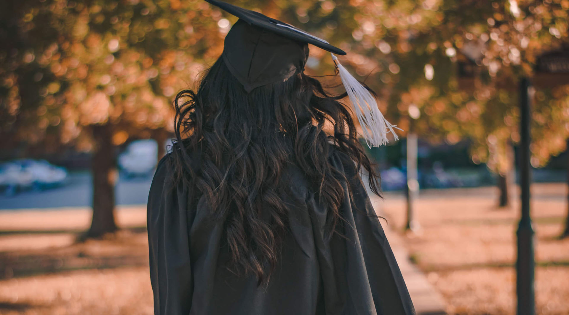 A person standing outside dressed in a graduation cap and gown