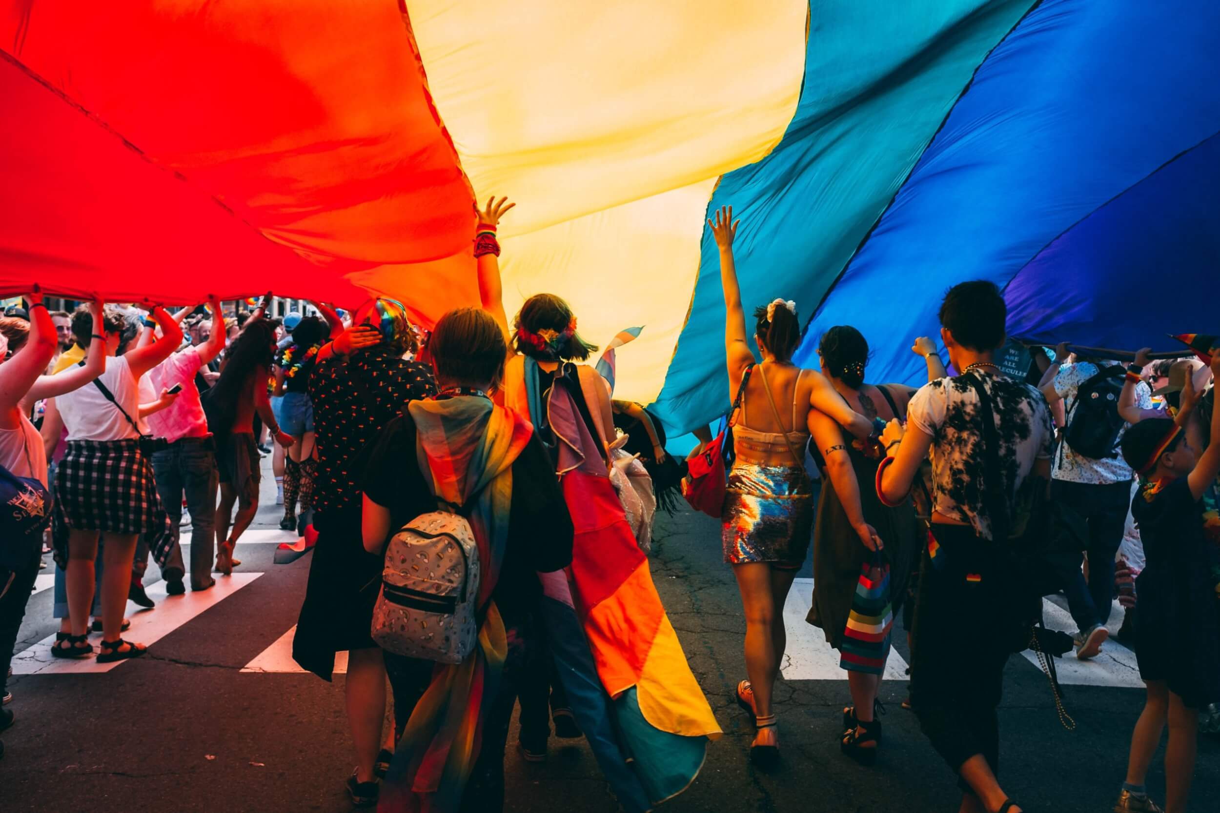 A group of people carrying a rainbow flag